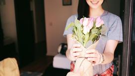 Женщине дарят букет тюльпанов