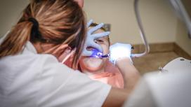 Стоматолог лечит зубы ребенку.