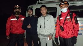 Спасатели стоят с нашедшимися гражданами на фоне служебной машины