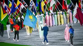 Спортсмен несет флаг Казахстана в Токио