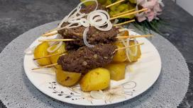 На сервировочной тарелки жареные люля-кебабы с картофелем
