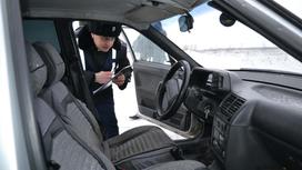 Полицейский осматривает автомобиль