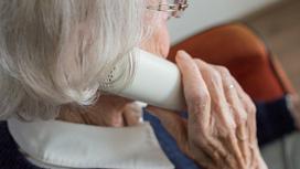 Пожилая женщина разговаривает по телефону