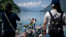 Туристы делают сэлфи на фоне озера