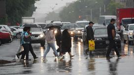 Люди переходят дорогу в дождь