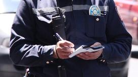 Полицейский что-то записывает в свой блокнот
