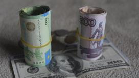 Тенге, рубли и доллары лежат на столе