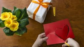 Из красной бумаги вырезают сердечко, упакованный подарок, фиалки