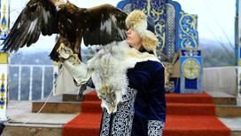 Мужчина в казахской национальной одежде с беркутом на руке