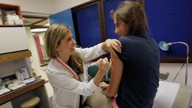 Медсестра ставит вакцину девушке