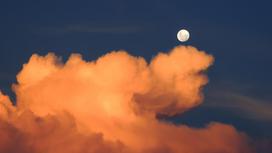 Луна плывет по небу в облаках