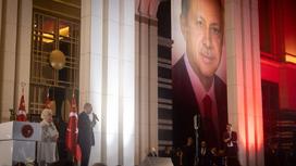 Фото Реджепа Тайипа Эрдогана на баннере и он сам, выступающий перед публикой