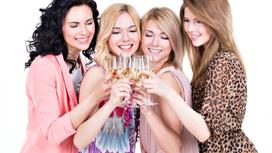 Четыре девушки держат в руках бокалы с шампанским и улыбаются