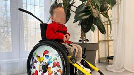 Мальчик сидит в инвалидной коляске