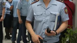 Полицейский стоит с папкой в руках