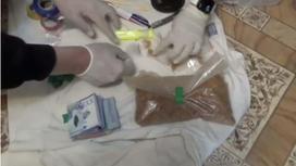 Оперативники раскладывают свертки с наркотиками