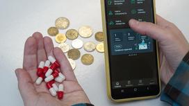 Приложение Damumed на смартфоне и лекарство в руках