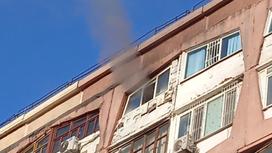 Дым выходит из окна квартиры жилого дома