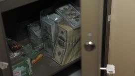 Пачки долларов и тенге в сейфе