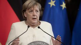 Ангела Меркель стоит за трибуной