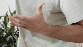 Мужчина машет рукой