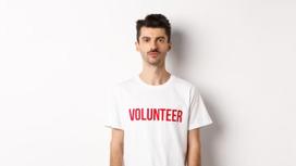 Мужчина в футболке с надписью «Волонтер»