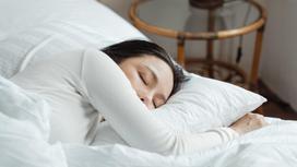Девушка спит на белой подушке