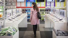 Женщина рассматривает товар в магазине электроники