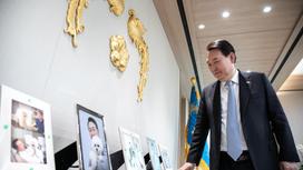 Президент Южной Кореи Юн Сок Ель смотрит на фото своих собак