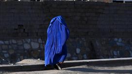 Афганская женщина идет по дороге