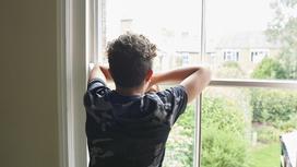 Подросток смотрит в окно