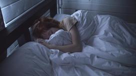 Девочка лежит в кровати под одеялом