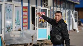 Мужчина стоит возле бутика на рынке