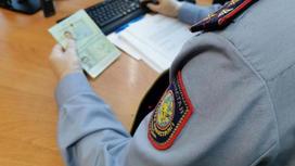 Полицейский проверяет данные в паспорте