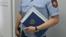 полицейский держит папку с документами