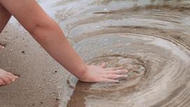 Ребенок трогает воду