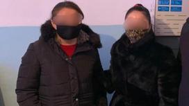 Две женщины в масках и верхней одежде стоят рядом друг с другом