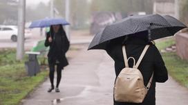 Девушки с зонтами идут по улице