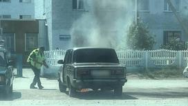 Полицейский тушит авто