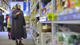 Бабушка смотрит на цены в супермаркете