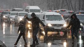 люди переходят дорогу под снегом