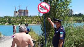 Спасатель объясняет мужчине, что купаться запрещено
