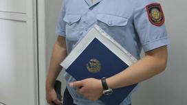 Полицейский стоит с документами в руках