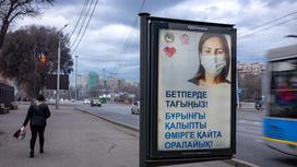 Билборд с девушкой в маске стоит на улице