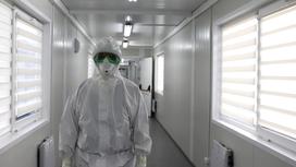 Медработник стоит в коридоре инфекционной больницы