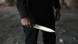 Мужчина стоит с ножом в руке