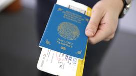 Мужчина держит паспорт с билетами на самолет