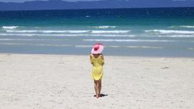 Девушка в шляпе смотрит на море