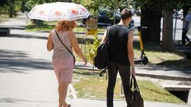 Парень и девушка идут по улице летом