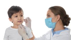 Доктор смазывает высыпания у ребенка на лице